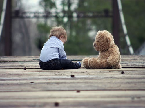 a child sitting with a teddy bear
