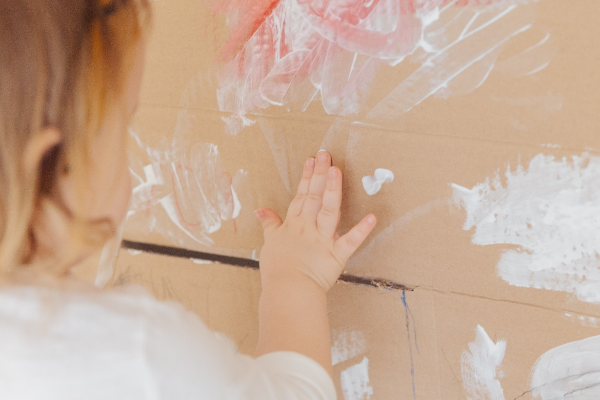 A child drawing with white paint