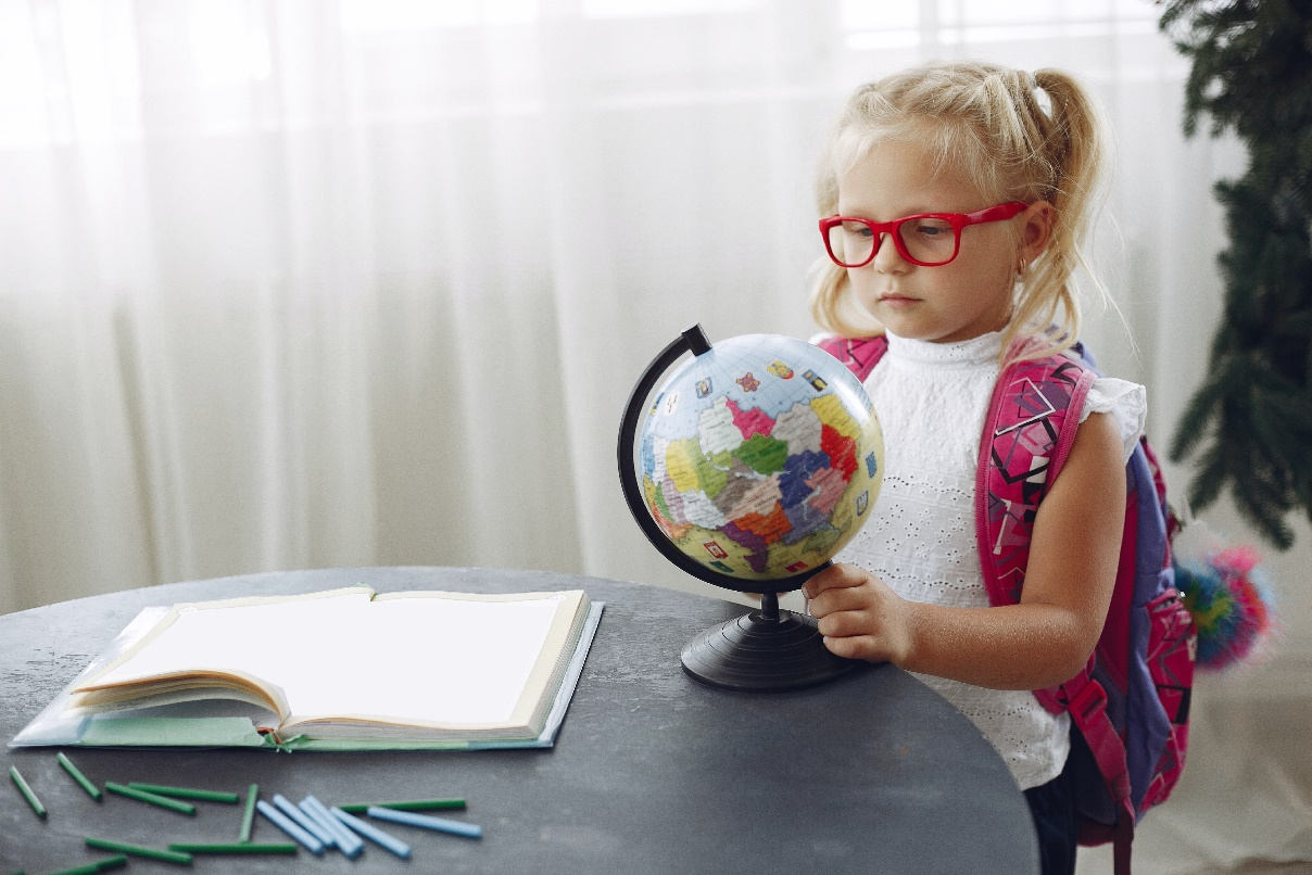 A little girl studying the globe
